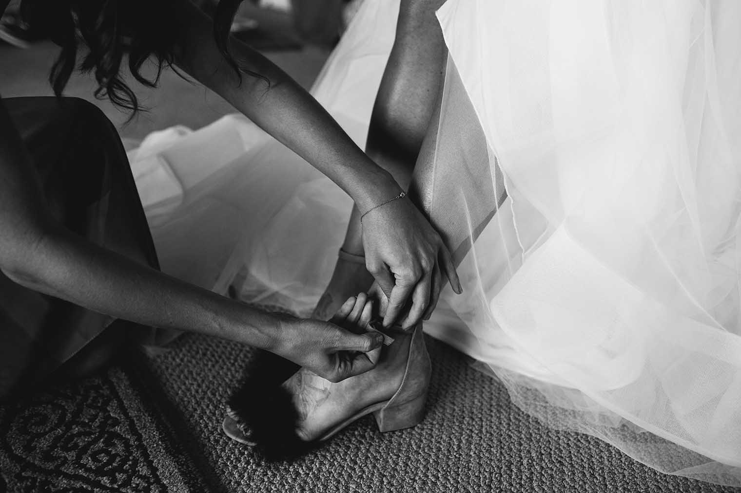 Bride putting on wedding shoes